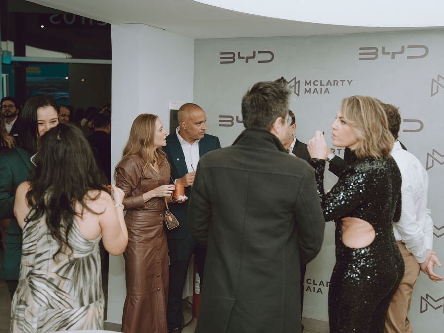 Convidados conversando diante do painel BYD McLarty Maia